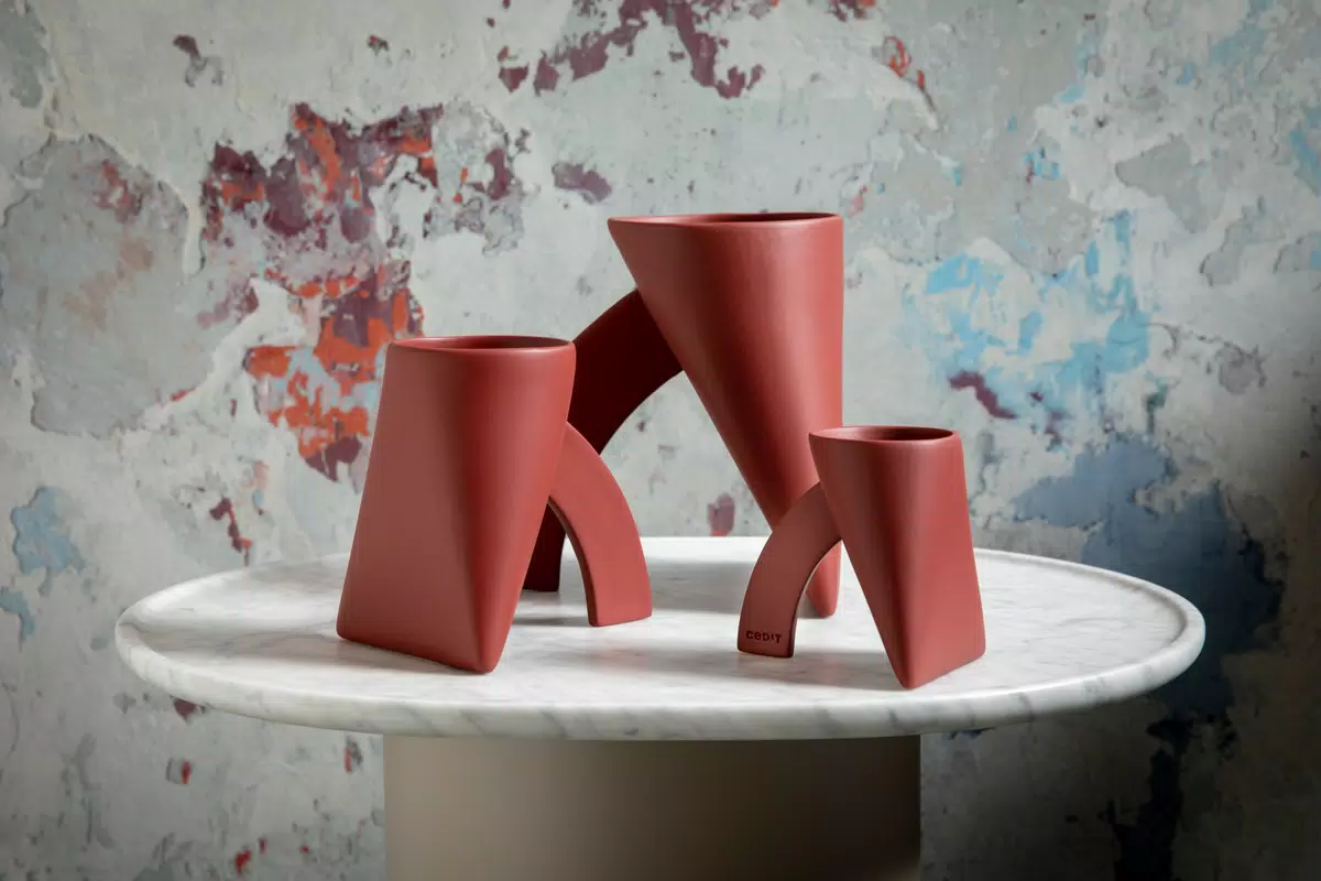 Three red Lapis re-edition vases on a small round table
