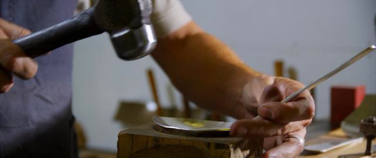 Allan Adler first round — current film poster showing a silversmith hammering metal