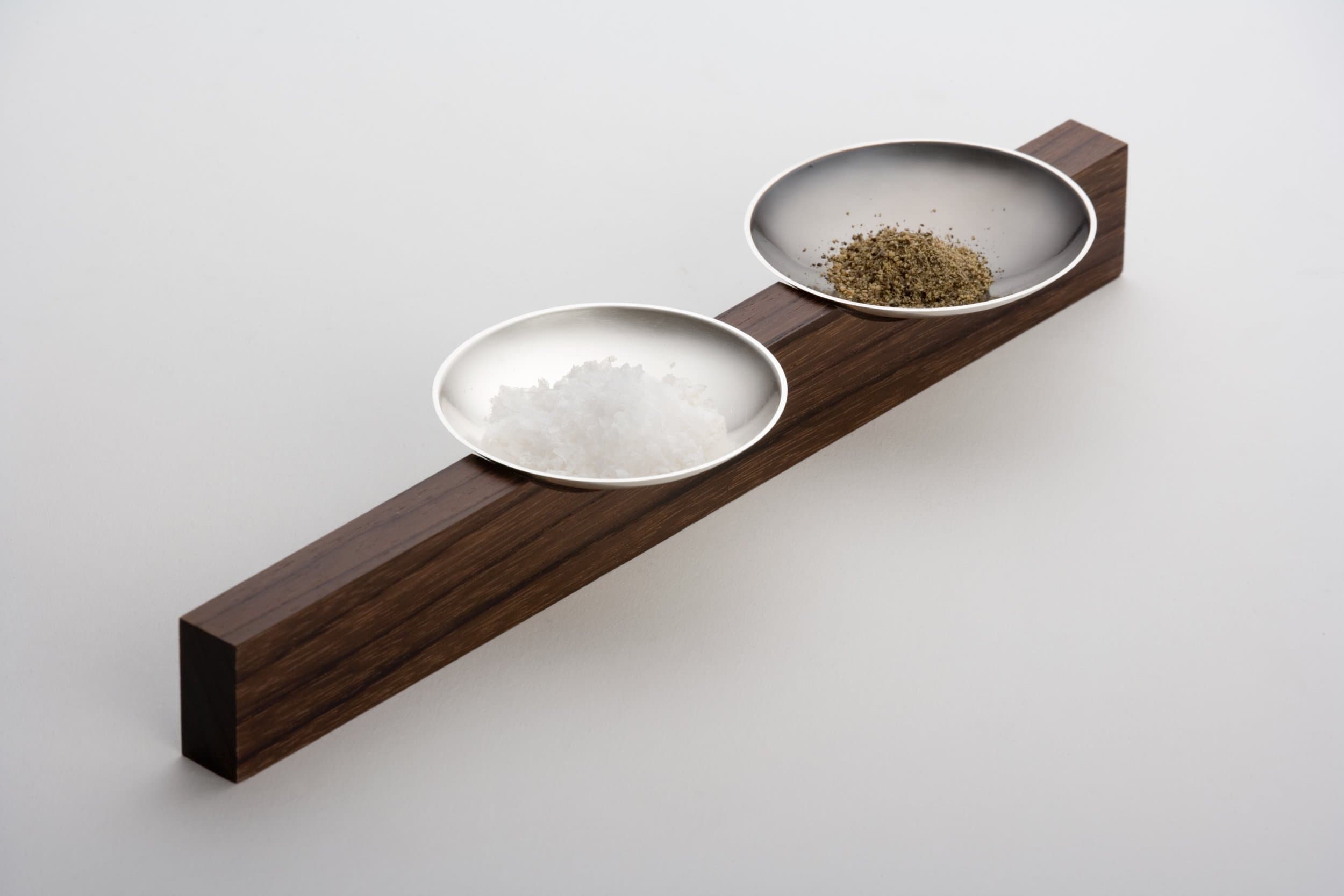 Jacqueline Scholes: two salt-and-pepper dishes on a rosewood support. Photograph ©Sylvain Deleu.