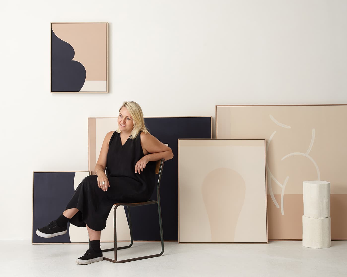 Caroline Walls seated among Over in Love paintings, photographed by Amorfo