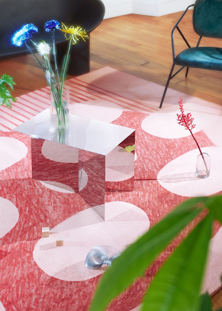 A pink geometric rug from Guillaume Delvigne’s 2019 anniversary collection, photographed with reflective tables and flowers