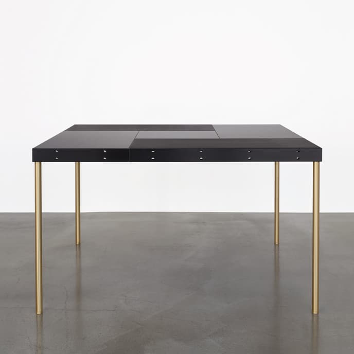 A dark-topped MAP table by Martin Szekely, showing its joined rectangular modules and slender legs