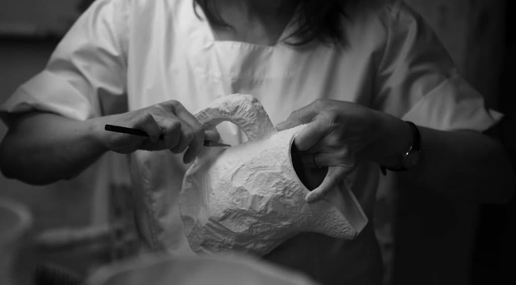 Crockery making process: finishing the hand-worked surface of the jug
