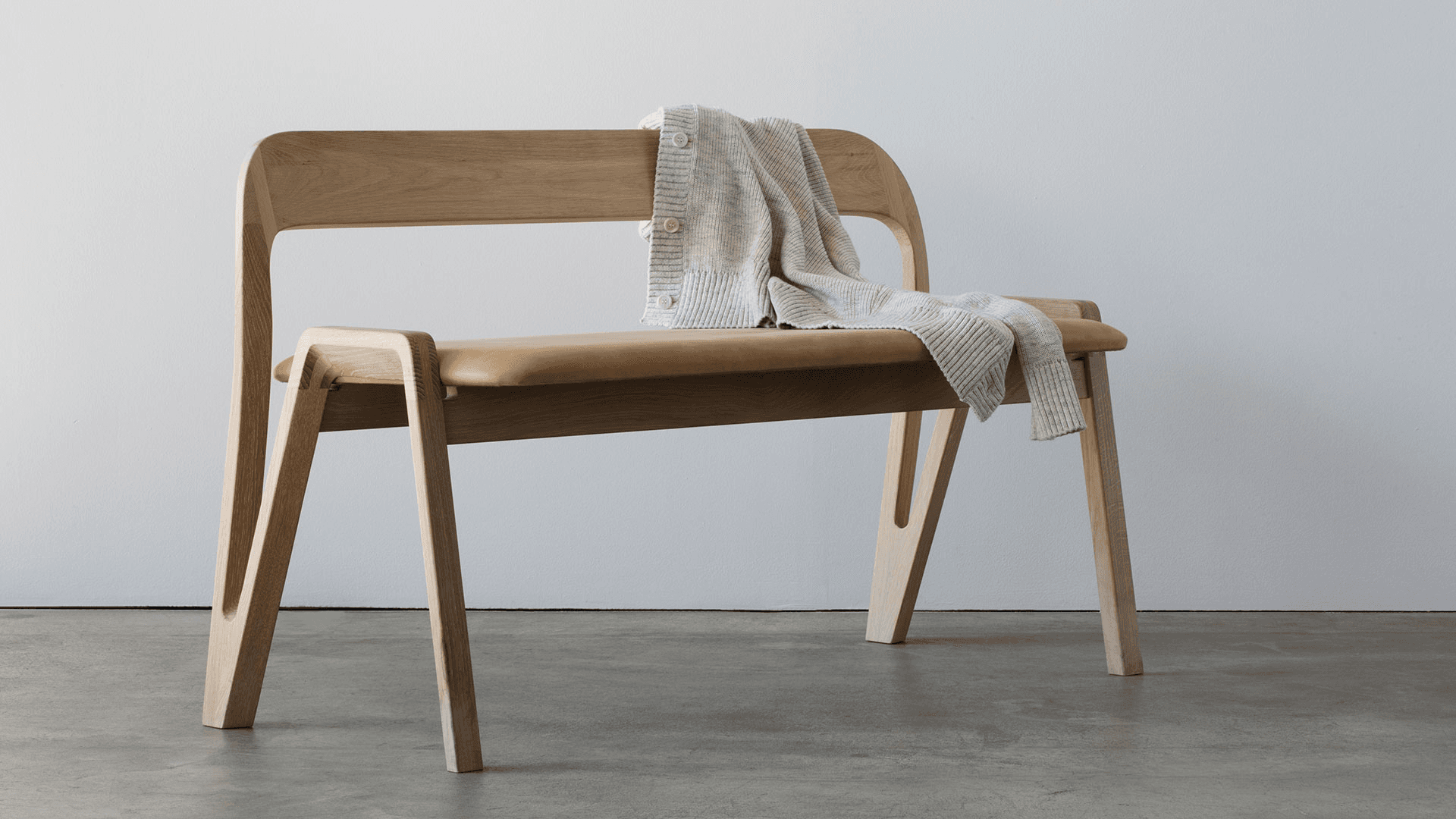 Under U02 oak bench with a textile draped across its back