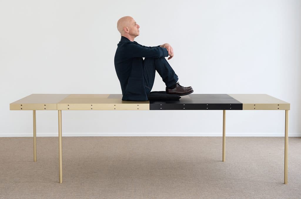A long MAP table configuration with a seated figure demonstrating its scale