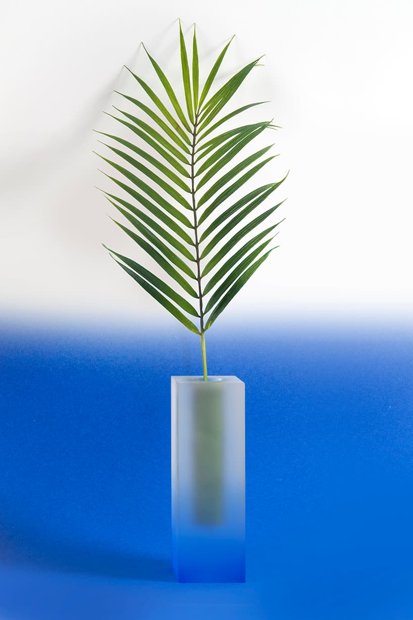 An indigo-toned blurred Mellow vase holding a palm frond