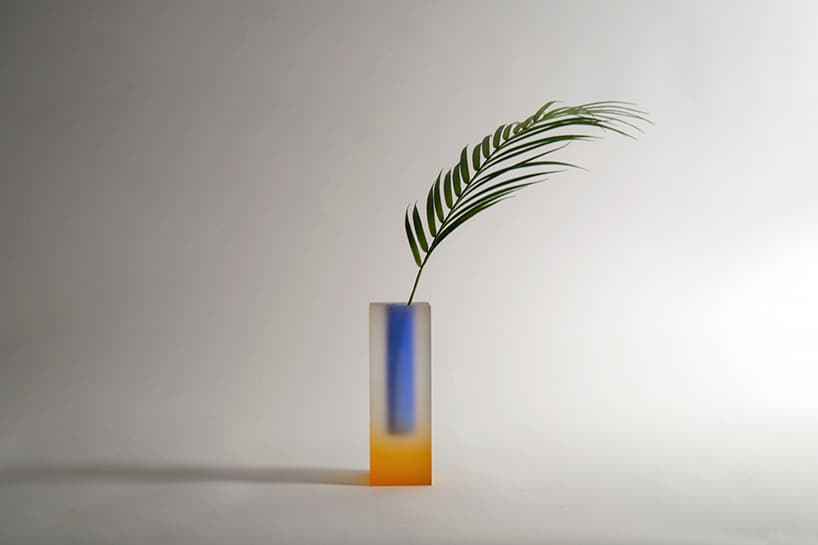 A yellow-and-blue blurred Mellow vase in a wide studio composition