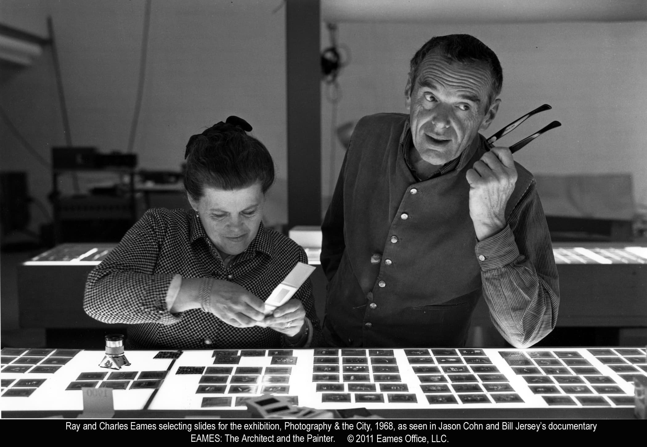 Ray and Charles Eames selecting slides for Photography & the City, 1968 (replacement image)