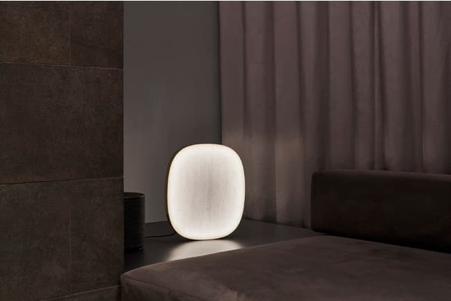 And-on brass and washi-paper light beside a sofa