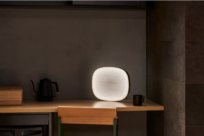 And-on brass and washi-paper light on a wooden desk