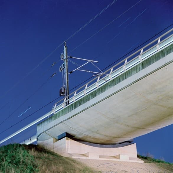 Sander Meisner’s Viaducts #3, a pale concrete bridge crossing diagonally against deep blue sky.