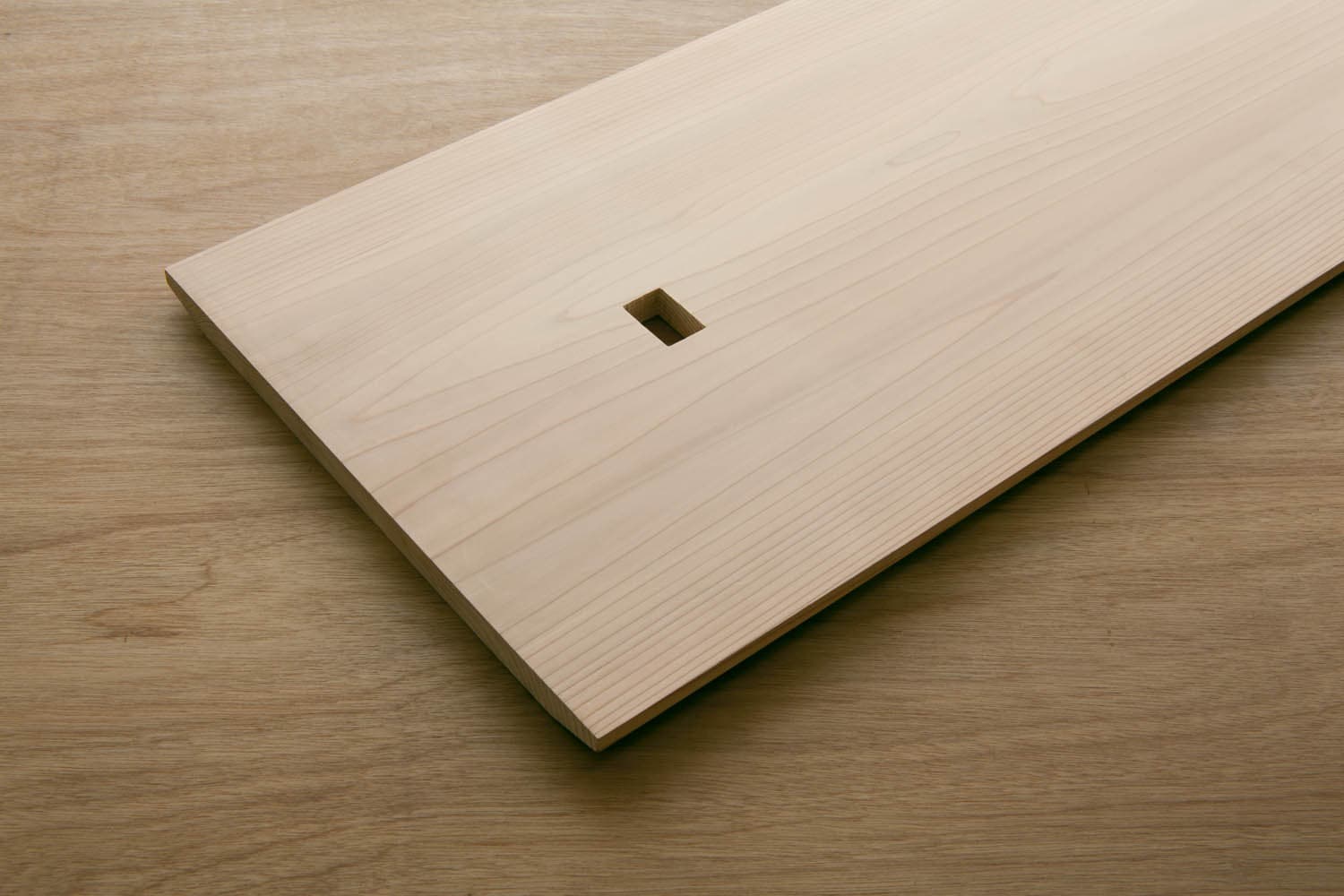 Cedar shelf panel showing its grain and square connection opening.