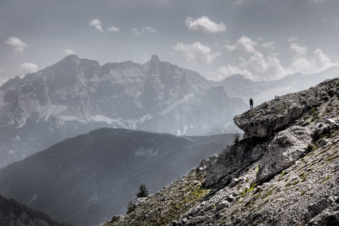 Small figure on a rock ledge above a mountain valley, Pierch from PERAT by Gustav Willeit
