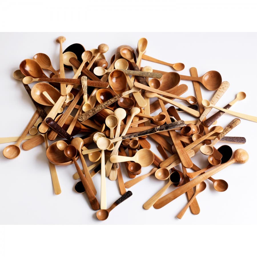 A pile of hand-carved wooden spoons and utensils in various woods by Nic Webb.