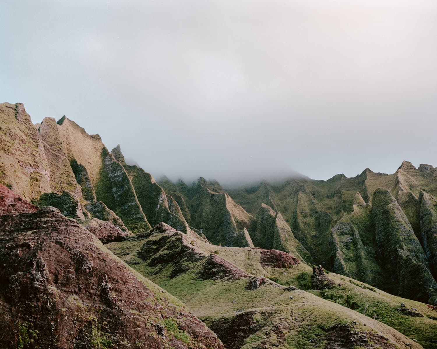 Steep green mountain ridges under low cloud.
