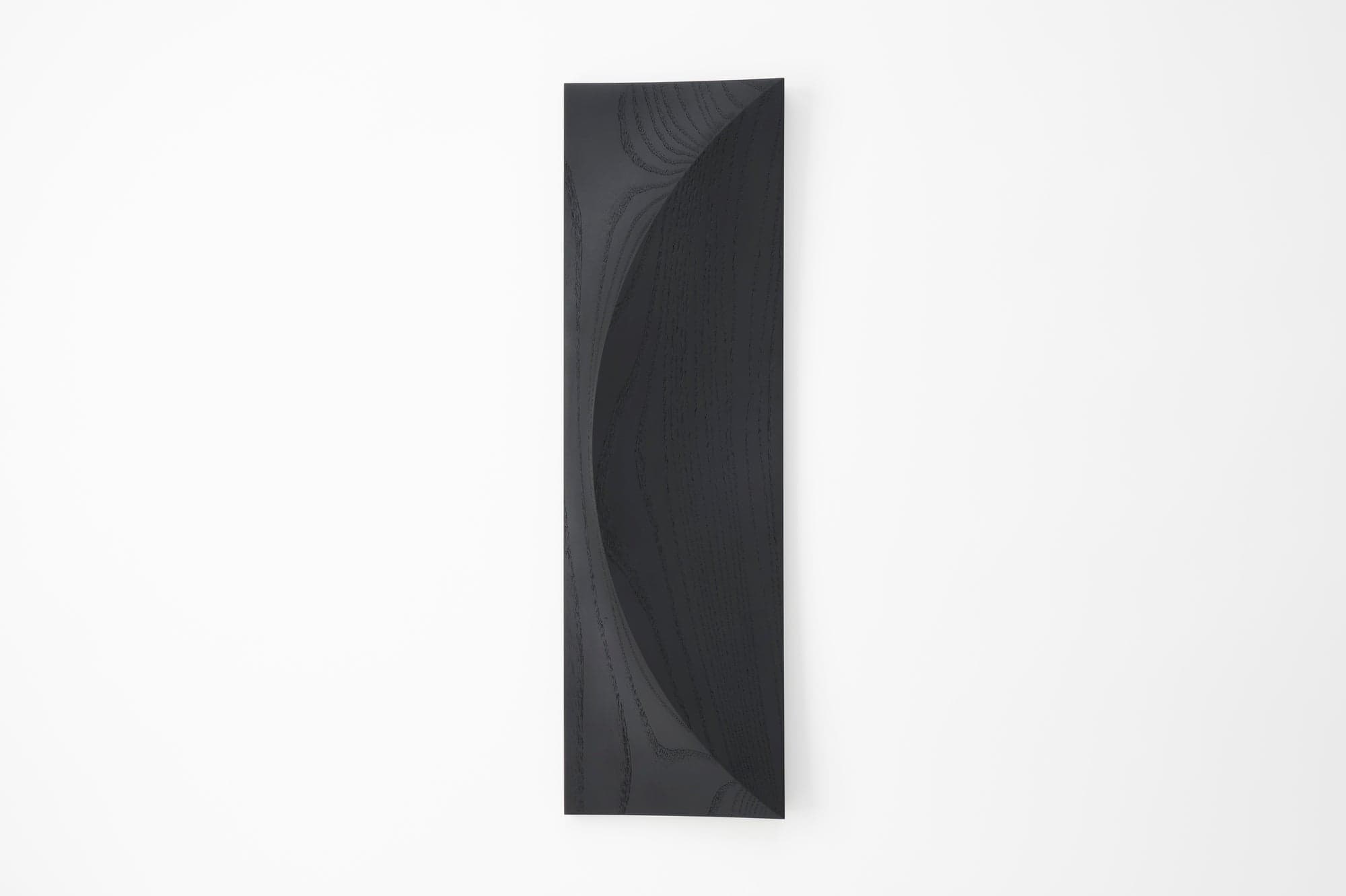 Current black-finished ash VASTO TRE wall object by IWATA, with a broad semicircular carved face.