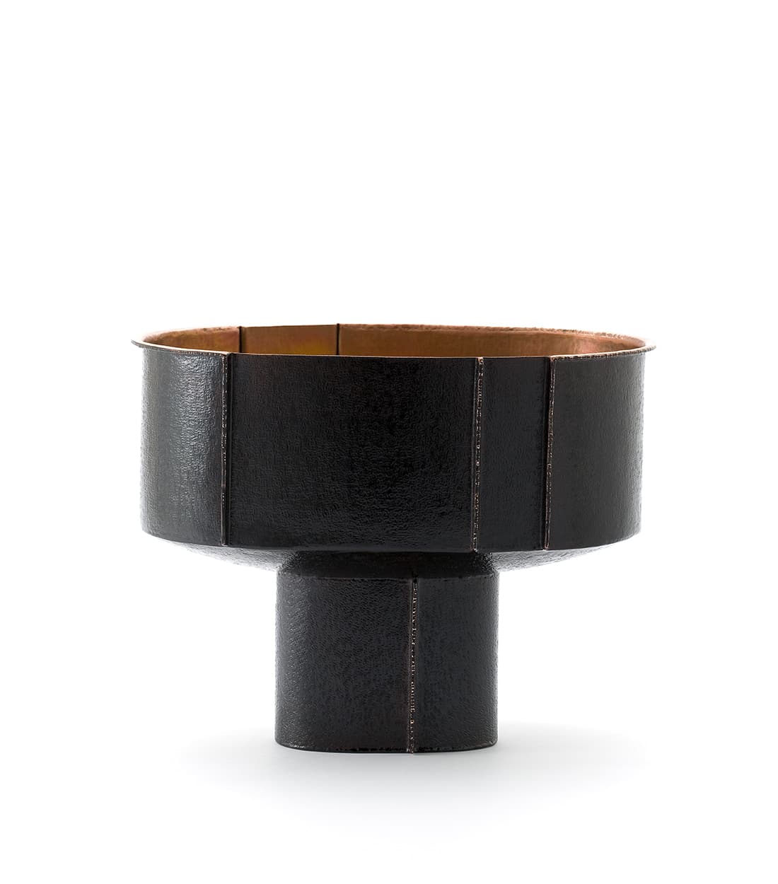 Dark patinated bowl on a cylindrical foot, with visible textured panels and vertical welded seams.