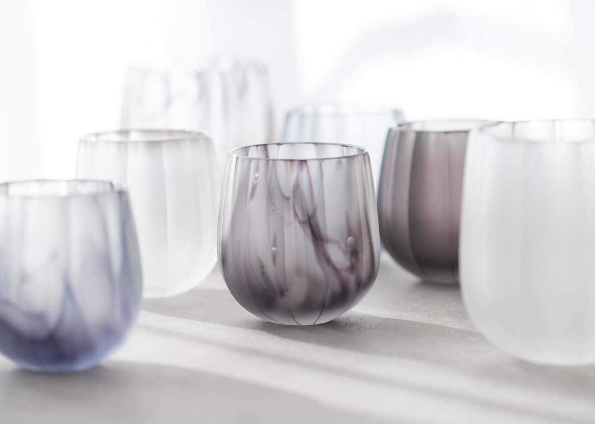 A group of rounded, translucent Yuki Osako tumblers in smoky purple, blue and frosted glass.