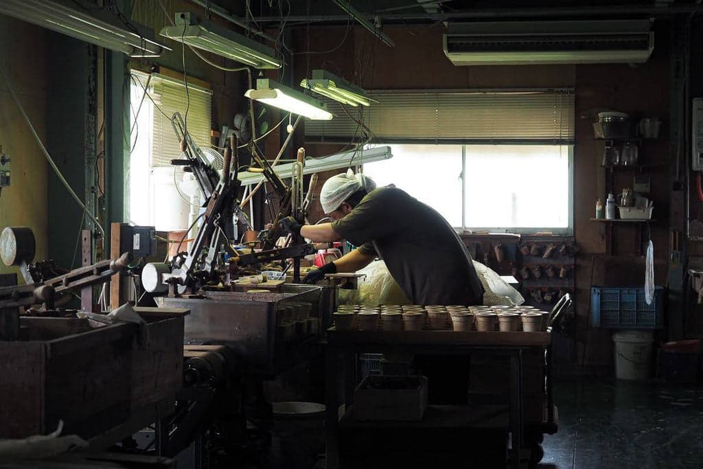 Working at a machine inside Nankei’s pottery workshop