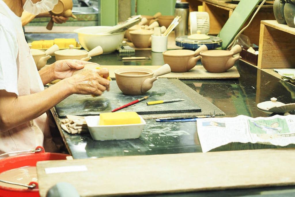 Hand-finishing pottery at a Nankei workbench