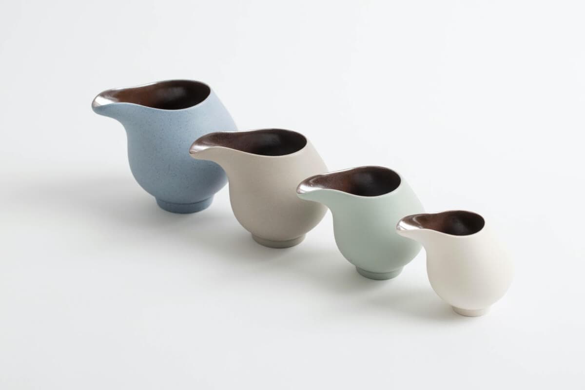 Kate Schuricht’s Flow Jugs, four graduated stoneware pouring vessels with matte pale exteriors and dark lustre interiors
