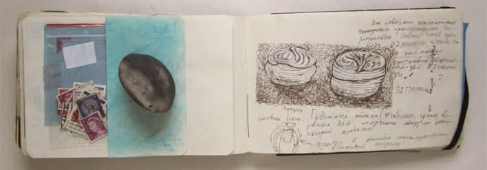 An open handmade notebook combines postage stamps and a dark oval clipping on the left with detailed pen drawings of two coiled forms and handwritten notes on the right.