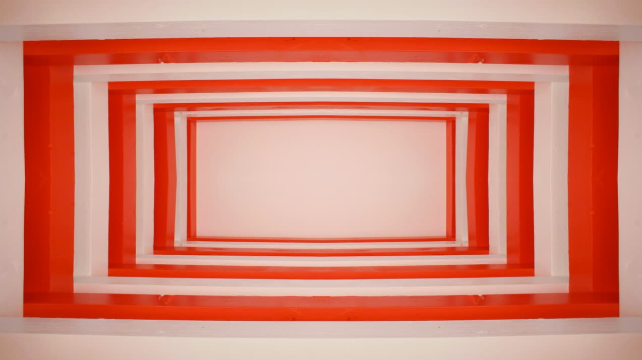 Red and white wooden strips form a series of nested rectangular frames around a pale centre.