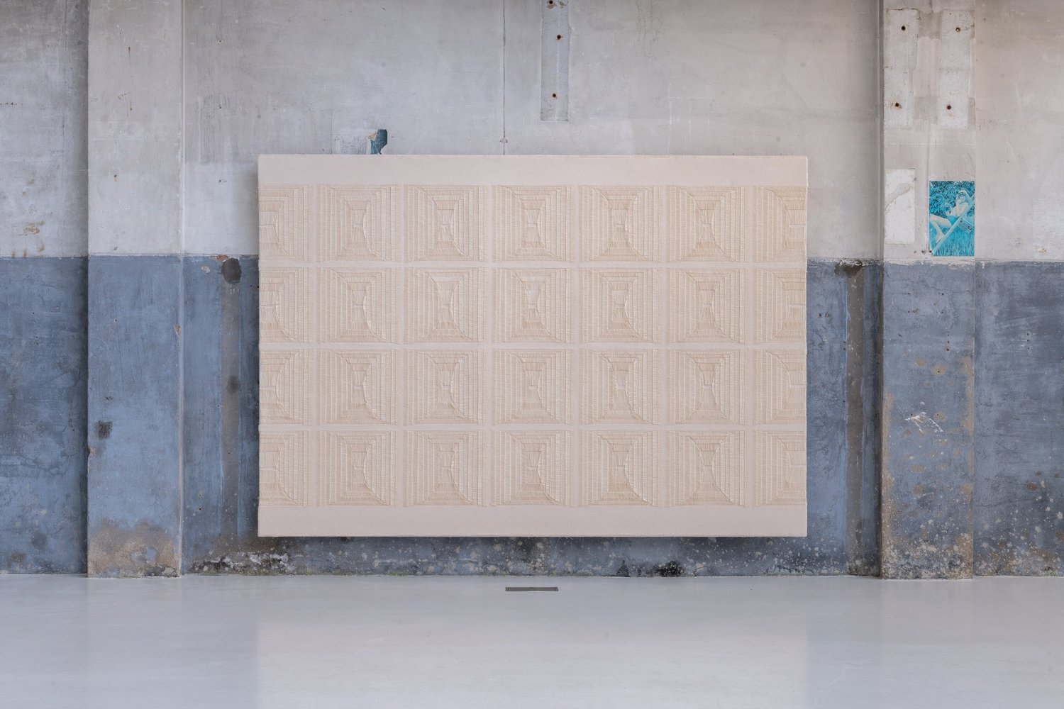 A broad rectangular canvas with four rows of repeated woven forms.