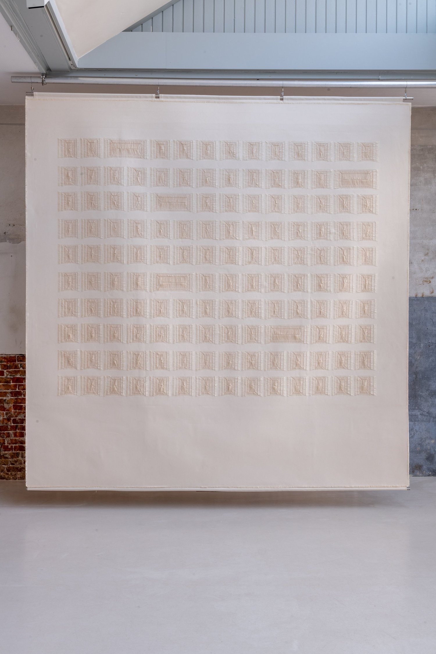 A square canvas filled with a dense grid of smaller woven forms.