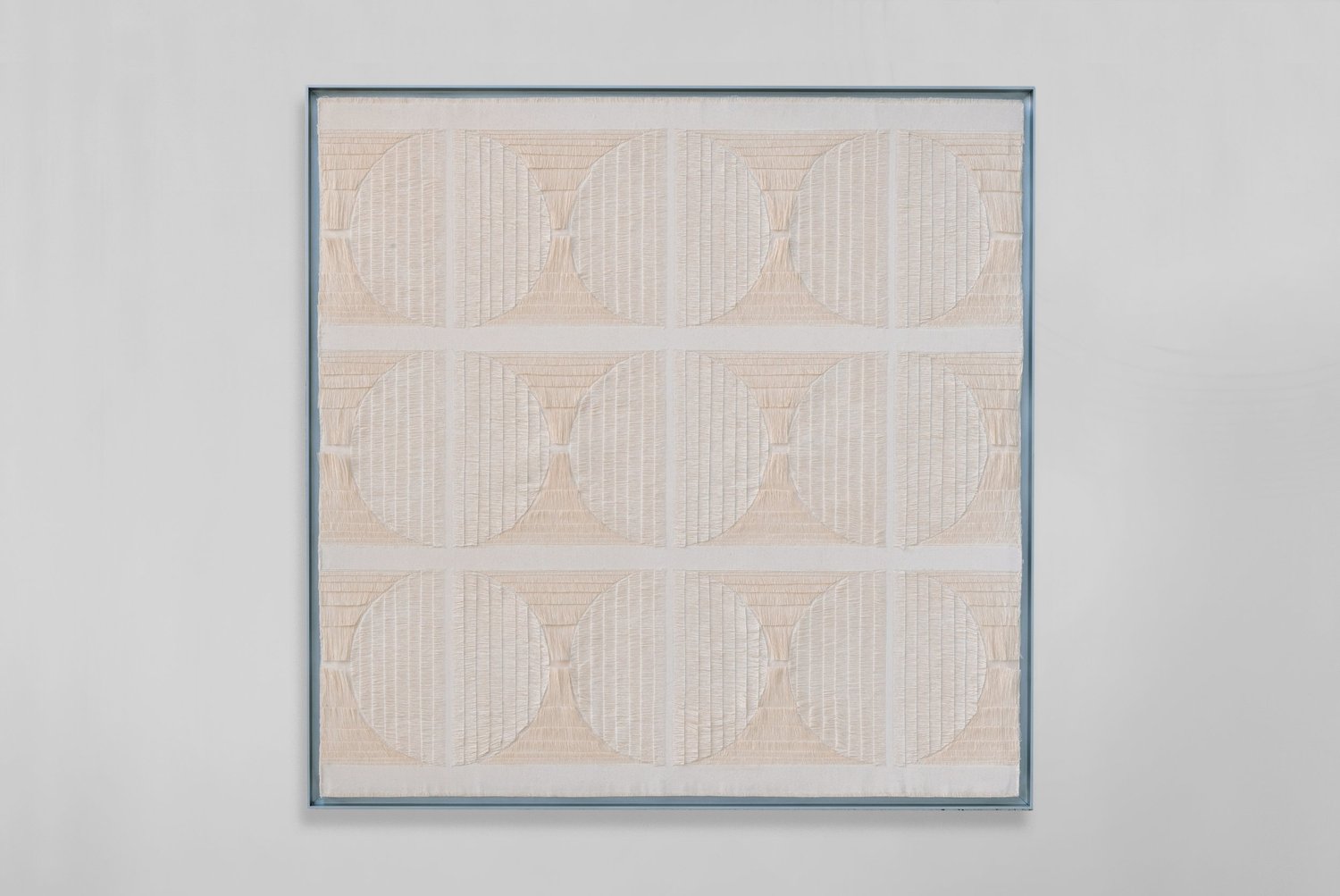 Nine rounded forms, arranged within a square cotton canvas.